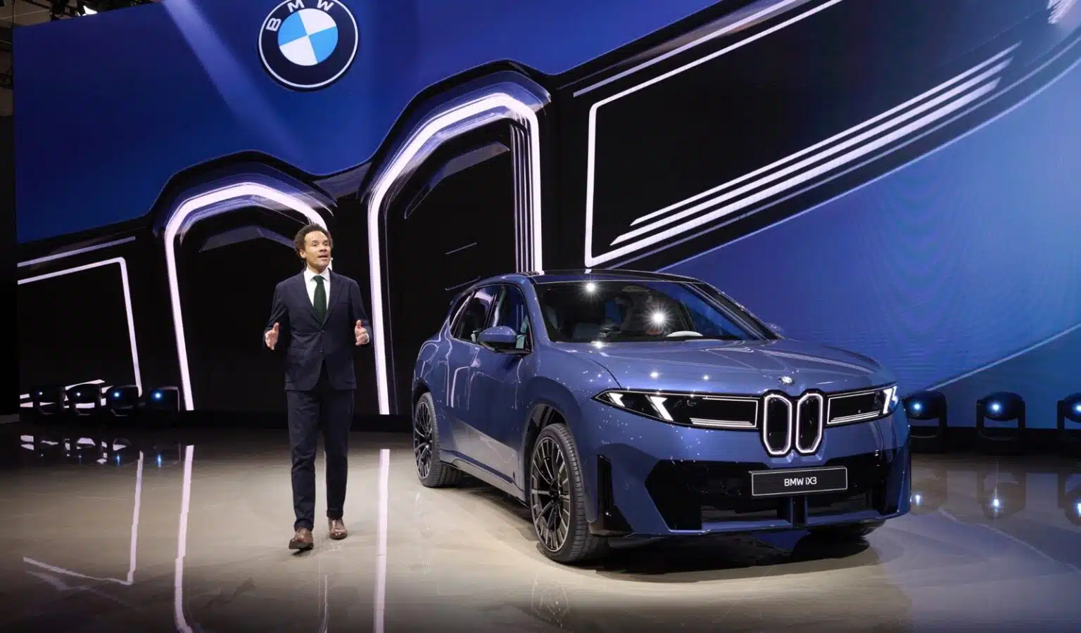Front fascia of the 2026 BMW iX3 showcasing new Neue Klasse design and 400 kW charging capability. Side profile of the BMW iX3 50 xDrive unveiled at the Japan Mobility Show 2025 with aerodynamic lines and modern styling.