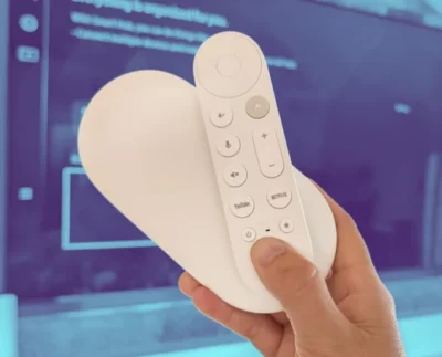 Chromecast with Google TV 4K streaming device connected to flat-screen TV showing Google TV interface and discounted sale banner.