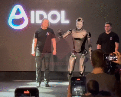 Russia’s first AI-powered humanoid robot stumbling during its debut demonstration. Engineers examining the fallen humanoid robot after the on-stage mishap. Close-up of the robot’s sensors and balance system used during the event. Audience reacting as the robot falls face-first during the presentation. Developers analyzing data from the robot’s fall to improve its stability. Humanoid robot practicing walking in a testing lab after the incident. Updated robot prototype demonstrating improved balance and mobility.