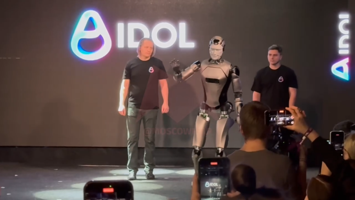 Russia’s first AI-powered humanoid robot stumbling during its debut demonstration. Engineers examining the fallen humanoid robot after the on-stage mishap. Close-up of the robot’s sensors and balance system used during the event. Audience reacting as the robot falls face-first during the presentation. Developers analyzing data from the robot’s fall to improve its stability. Humanoid robot practicing walking in a testing lab after the incident. Updated robot prototype demonstrating improved balance and mobility.