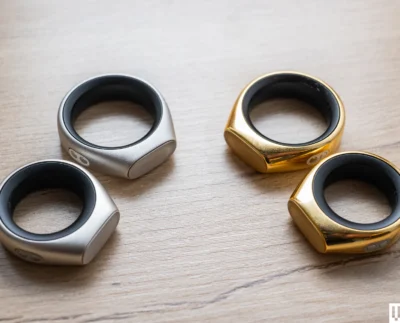 AI-Powered Smart Ring Close-Up – "Close-up of an AI-powered smart ring designed for voice input and thought organization." User Whispering to Smart Ring – "Person whispering into an AI smart ring to record thoughts privately and efficiently." Smart Ring Voice Recognition Technology – "Illustration showing how the smart ring captures whispers using advanced AI voice recognition." AI Thought Organization Interface – "Smartphone screen displaying organized notes and reminders synced from the AI smart ring." Gesture Control on Smart Ring – "User controlling smart ring functions through simple finger gestures and taps." Mindfulness and Productivity Tracking – "Dashboard view of the AI smart ring analyzing user mood and productivity trends." Future of Wearable AI Devices – "Concept image showcasing next-generation AI wearables, including smart rings and compact assistants."